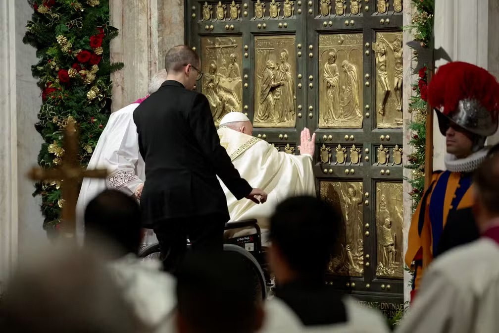 Sentado em uma cadeira de rodas, Papa Francisco abre as portas da Basílica de São Pedro, no Vaticano — Foto: REUTERS/Remo Casilli/Pool